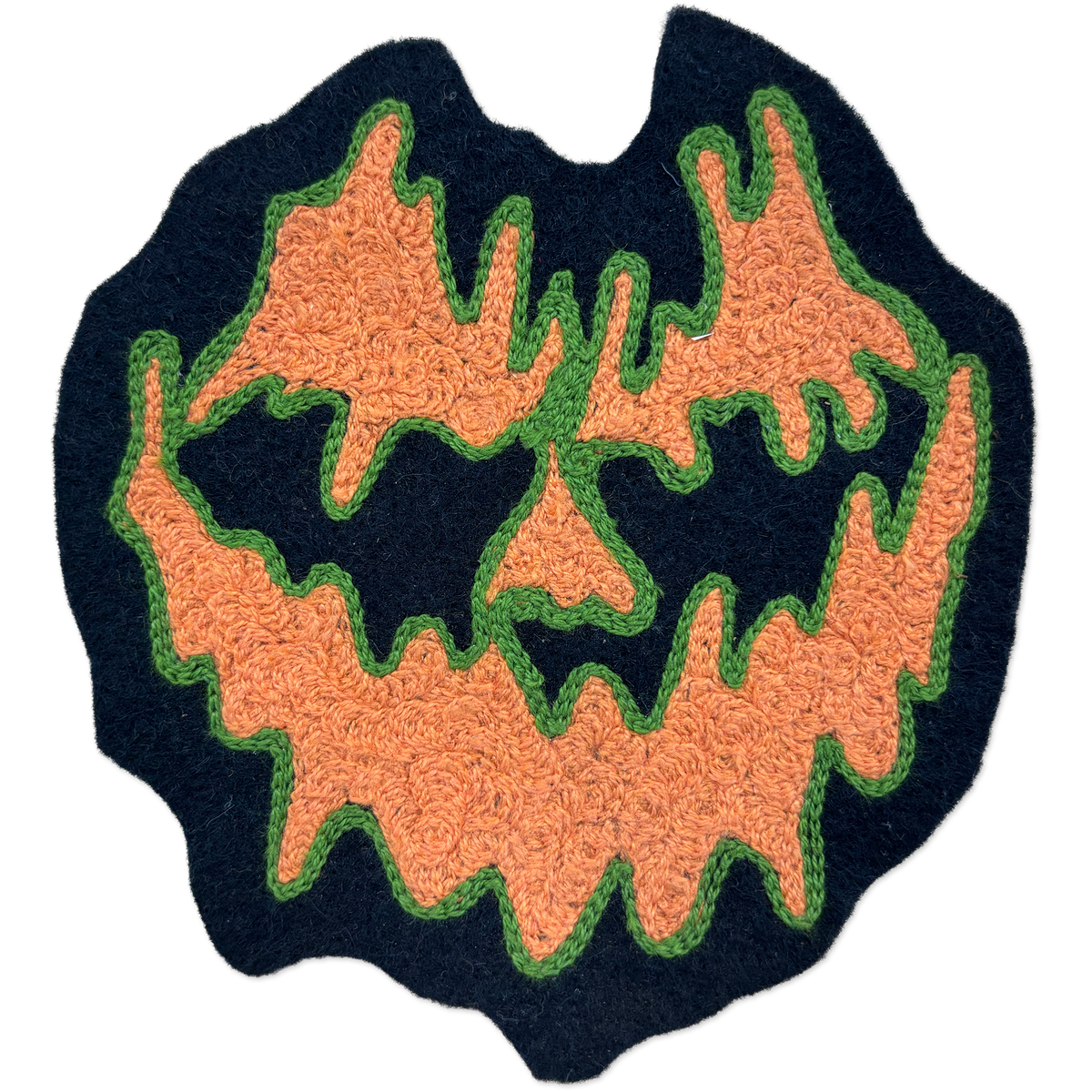 A Halloween-themed chainstitch patch featuring a spooky jack-o'-lantern face. The design has a dark navy blue base, orange textured facial features, and green stitched outlines, presented on a clean white background.