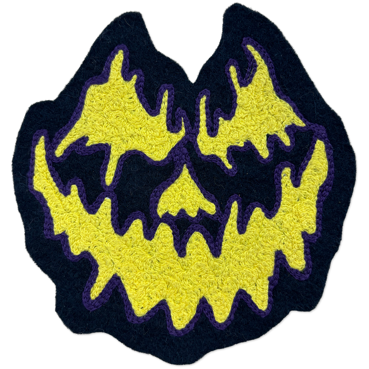 A chainstitch patch shaped like a jack-o'-lantern face, featuring a bright yellow textured design with a dark navy blue border and purple stitched outlines, isolated on a white background.
