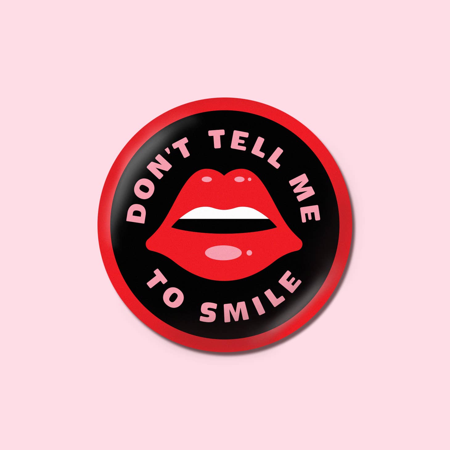 Button with the text "Don't tell me to smile" surrounding an illustration of lips.