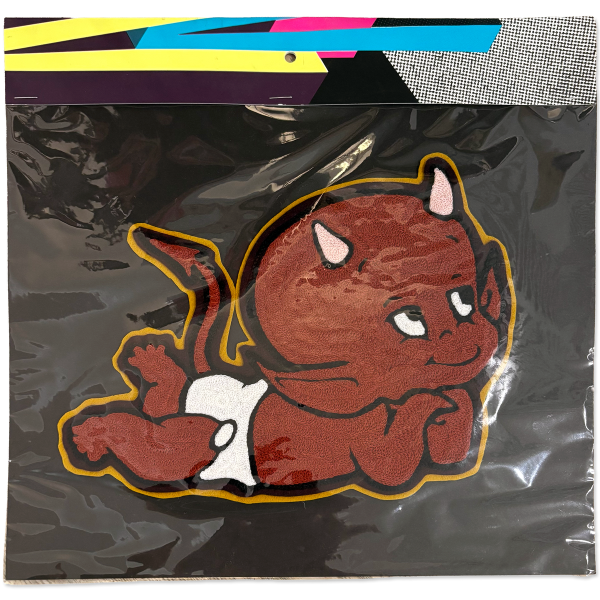 A packaged handmade chainstitch patch featuring a cartoon devil baby on a black backing, with a colorful header card visible at the top.