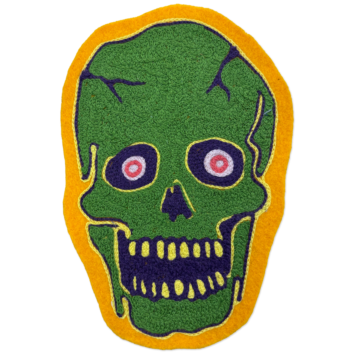 A green skull-shaped patch with a yellow border, featuring dark purple facial details and pink-and-white eyes, shown on a plain white background.